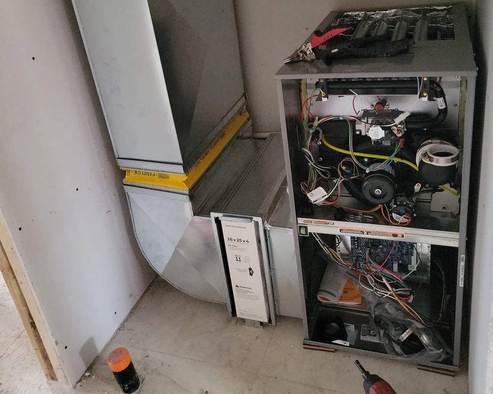 Expert gas furnace installation and testing in Kitchener Ontario, connecting high-quality ductwork to the new unit for optimal home heating performance.