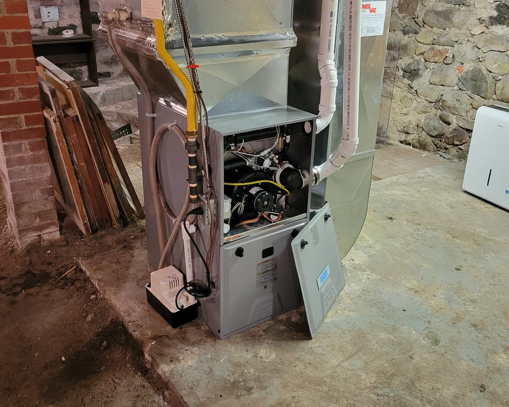 Annual gas furnace maintenance in Kitchener Ontario, showing HVAC technician performing a professional inspection and cleaning of the internal components.